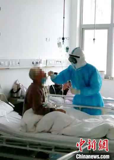 图为,医护人员在给患者取咽拭子,进行诊疗。山东大学齐鲁医院供图 山东支援湖北医疗队贡献战“疫”齐鲁智慧